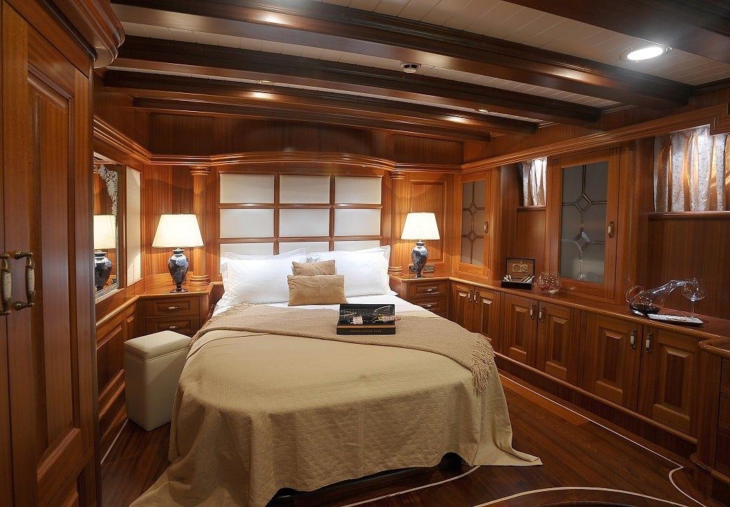 a bedroom with a bed and a desk aboard KAPTAN KADIR Yacht for Charter