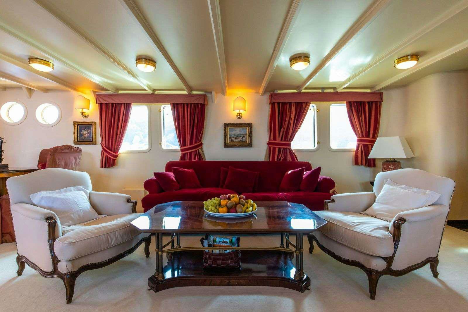 a living room with a table and chairs aboard DP MONITOR Yacht for Charter