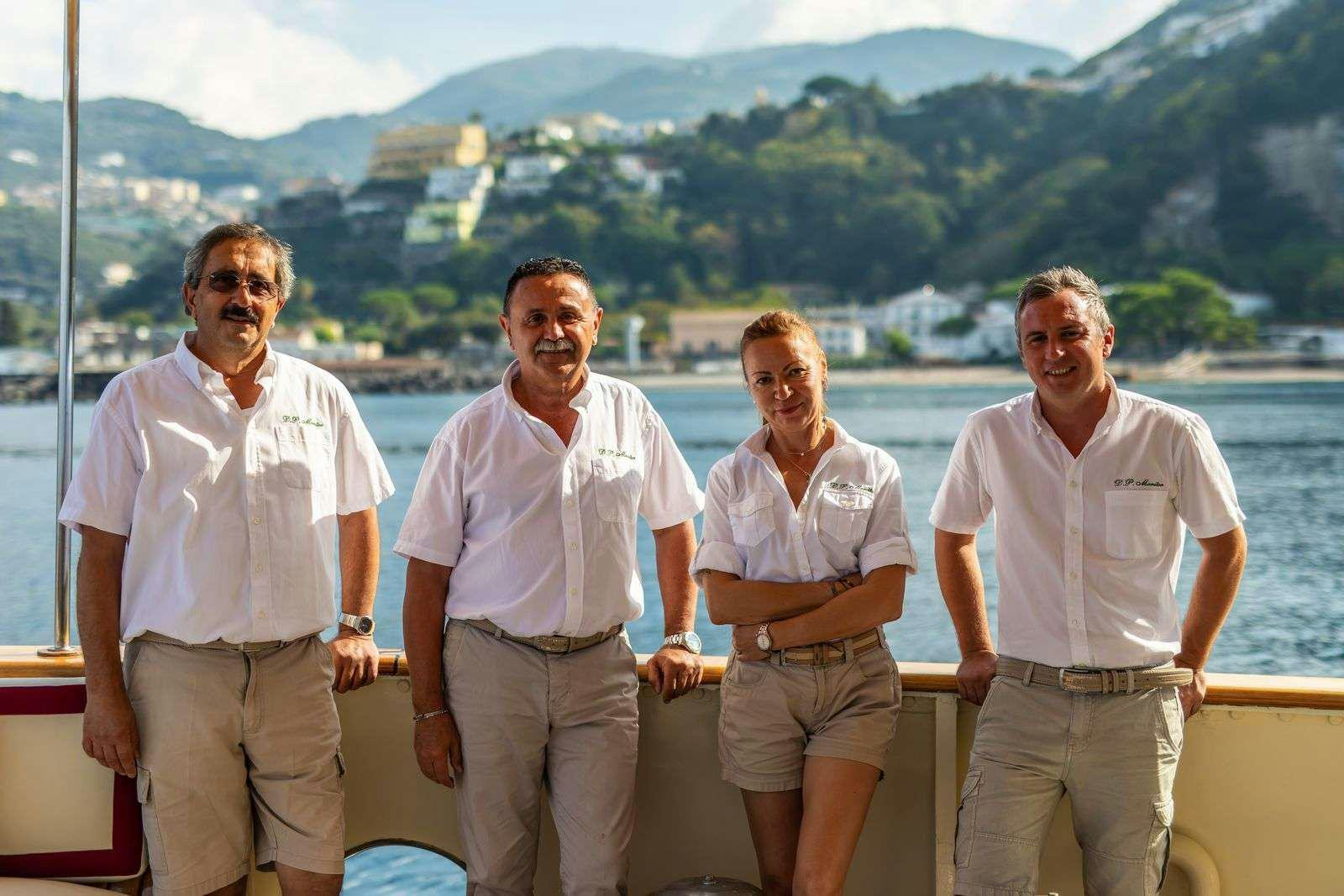 a group of people posing for a photo aboard DP MONITOR Yacht for Charter