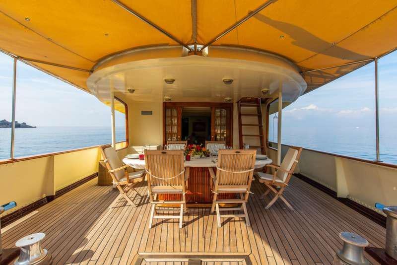 a room with a table and chairs aboard DP MONITOR Yacht for Charter