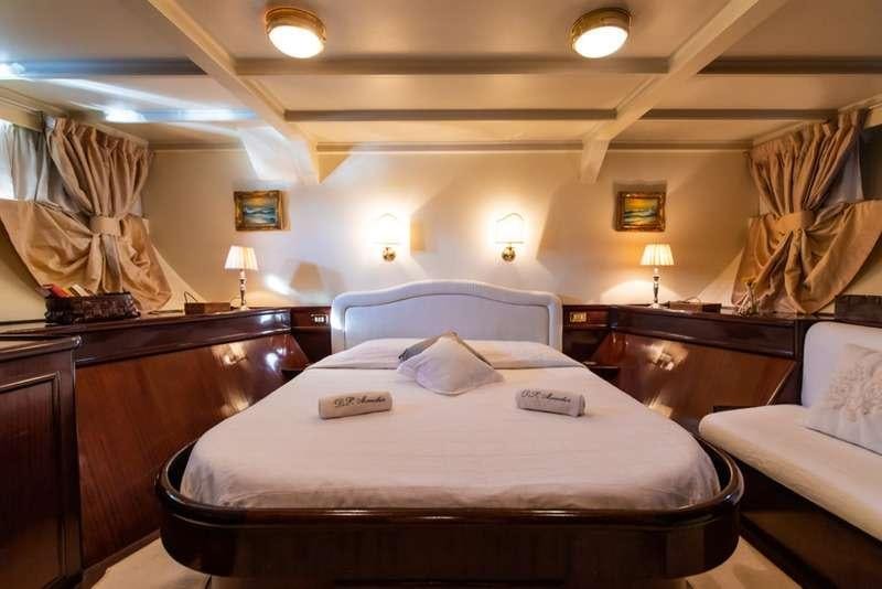 a hotel room with a bed and a chair aboard DP MONITOR Yacht for Charter