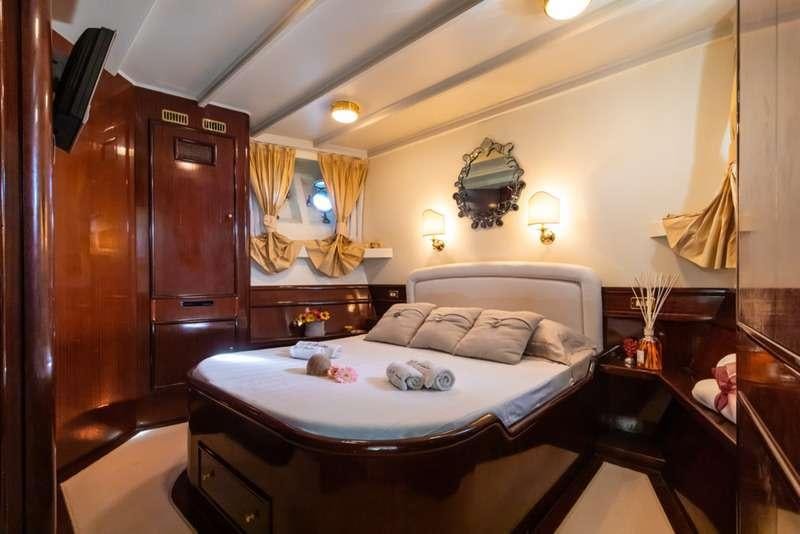 a bedroom with a bed and a dresser aboard DP MONITOR Yacht for Charter