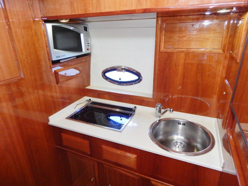 a kitchen with a microwave oven and a sink aboard SHINE Yacht for Charter