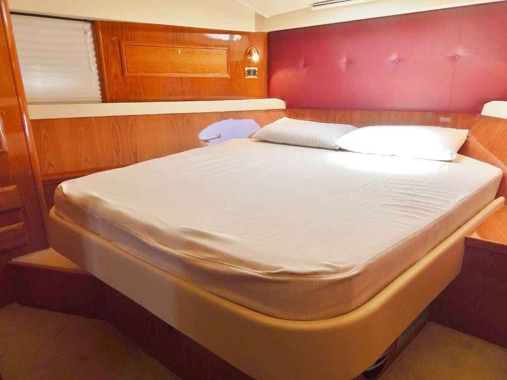 a bed with white sheets aboard SHINE Yacht for Charter