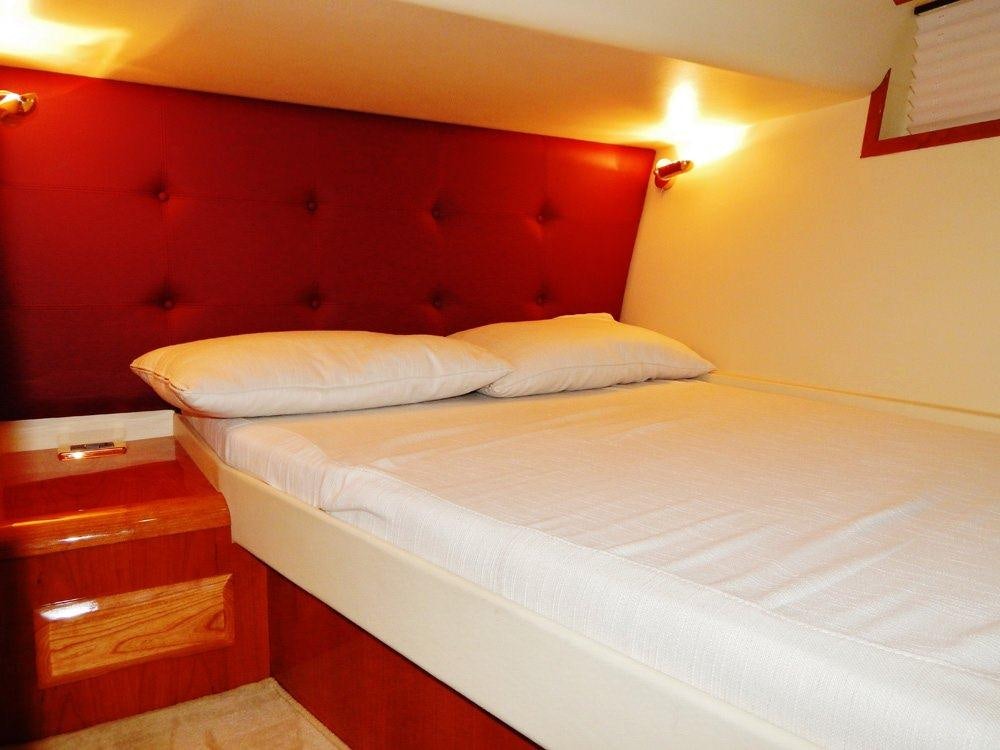 a bed with white sheets aboard SHINE Yacht for Charter