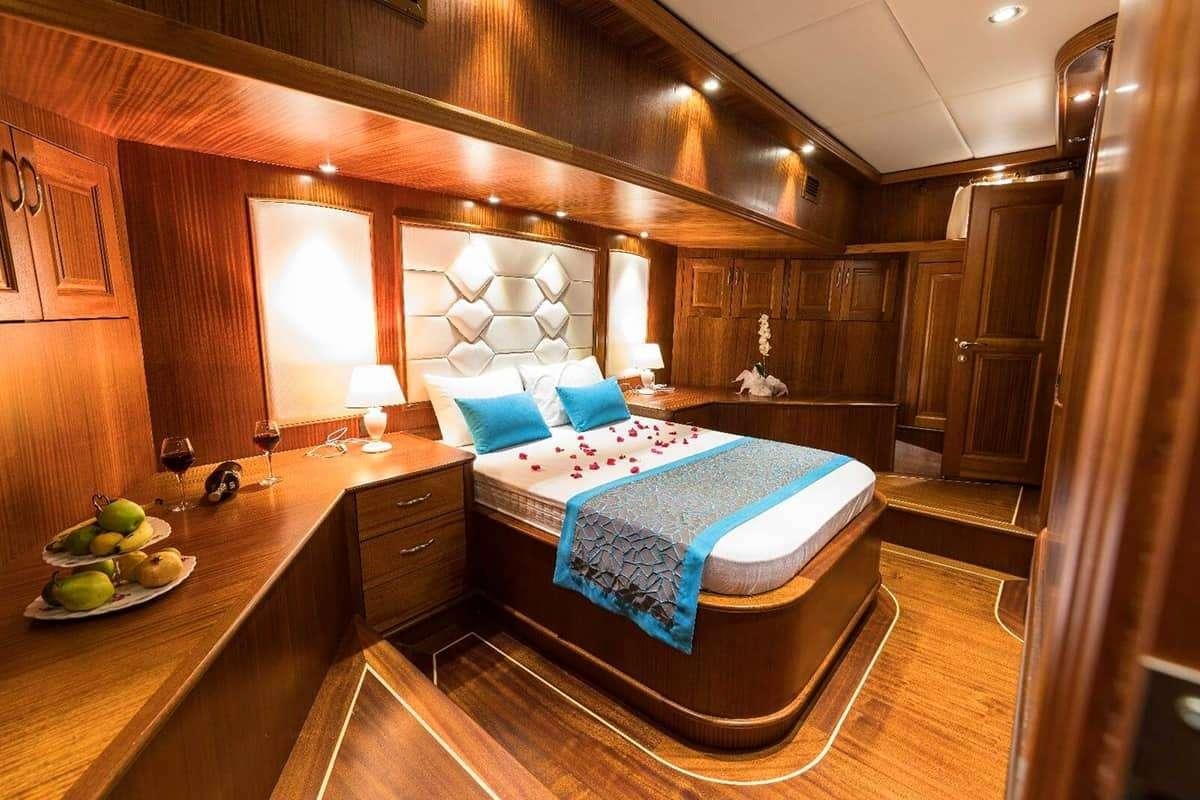 a bedroom with a bed and a table aboard VISTA MARE Yacht for Charter