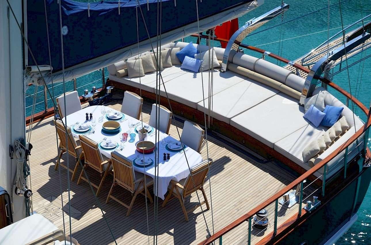 a large boat with a table and chairs aboard BLUE HEAVEN Yacht for Charter