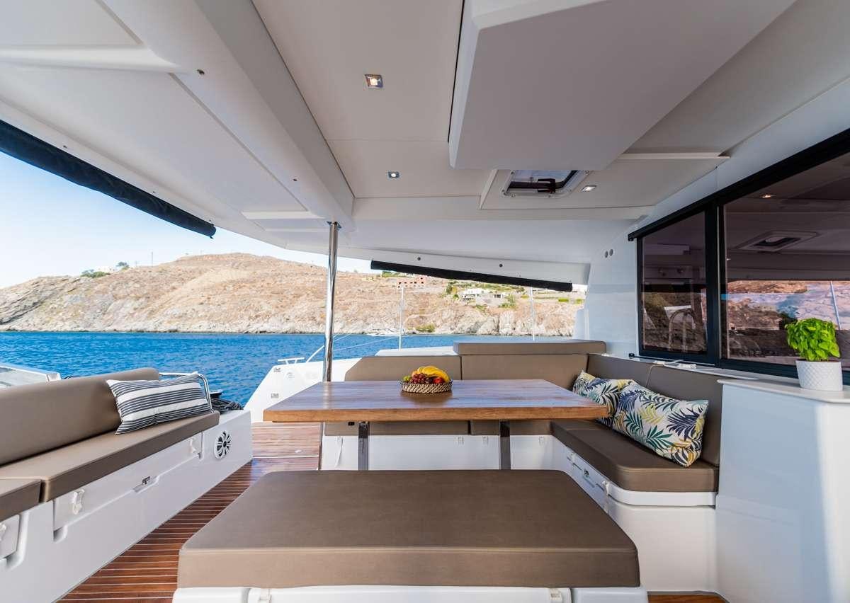 a room with a table and a couch aboard WHITE CORAL Yacht for Charter
