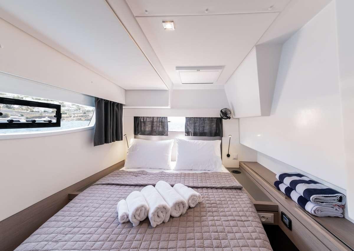 a bedroom with a bed and a window aboard WHITE CORAL Yacht for Charter
