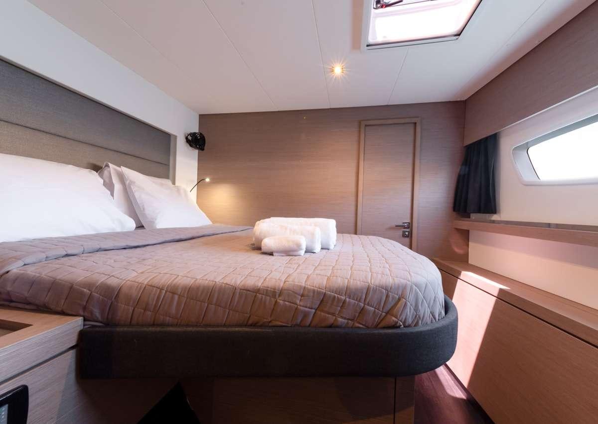a bed with white sheets aboard WHITE CORAL Yacht for Charter