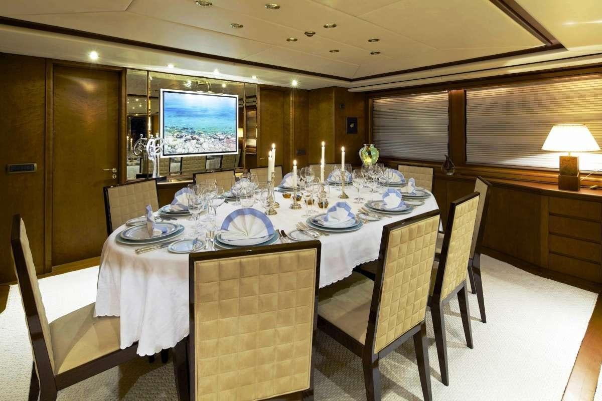 a dining room with a table set for a dinner aboard IDYLLE Yacht for Charter