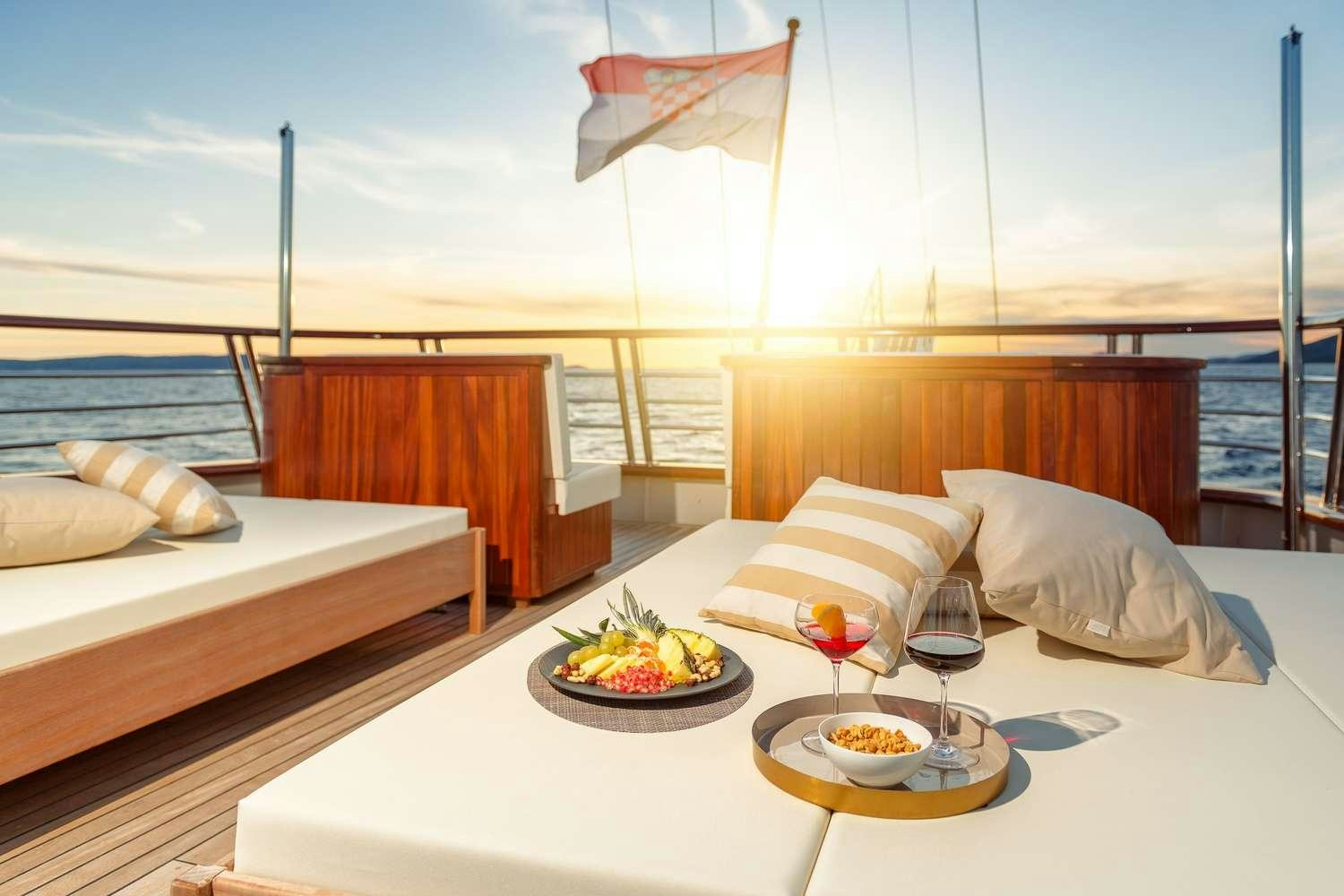 a room with a bed and a table with food on it aboard SON DE MAR Yacht for Charter