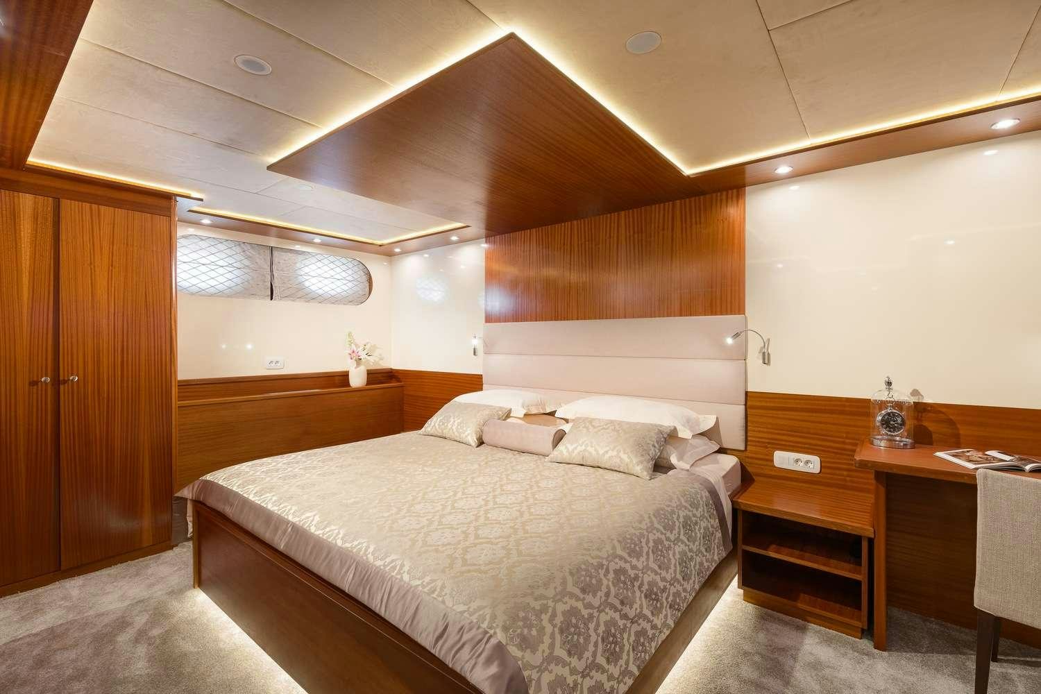a bedroom with a bed and desk aboard SON DE MAR Yacht for Charter