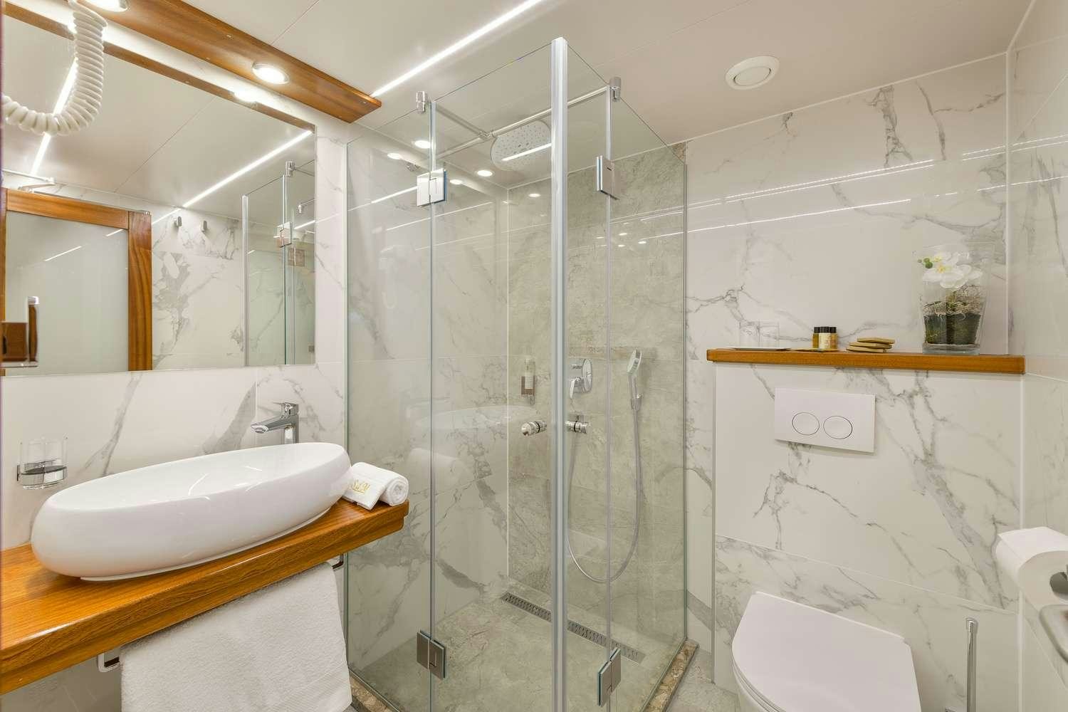 a bathroom with a glass shower aboard SON DE MAR Yacht for Charter