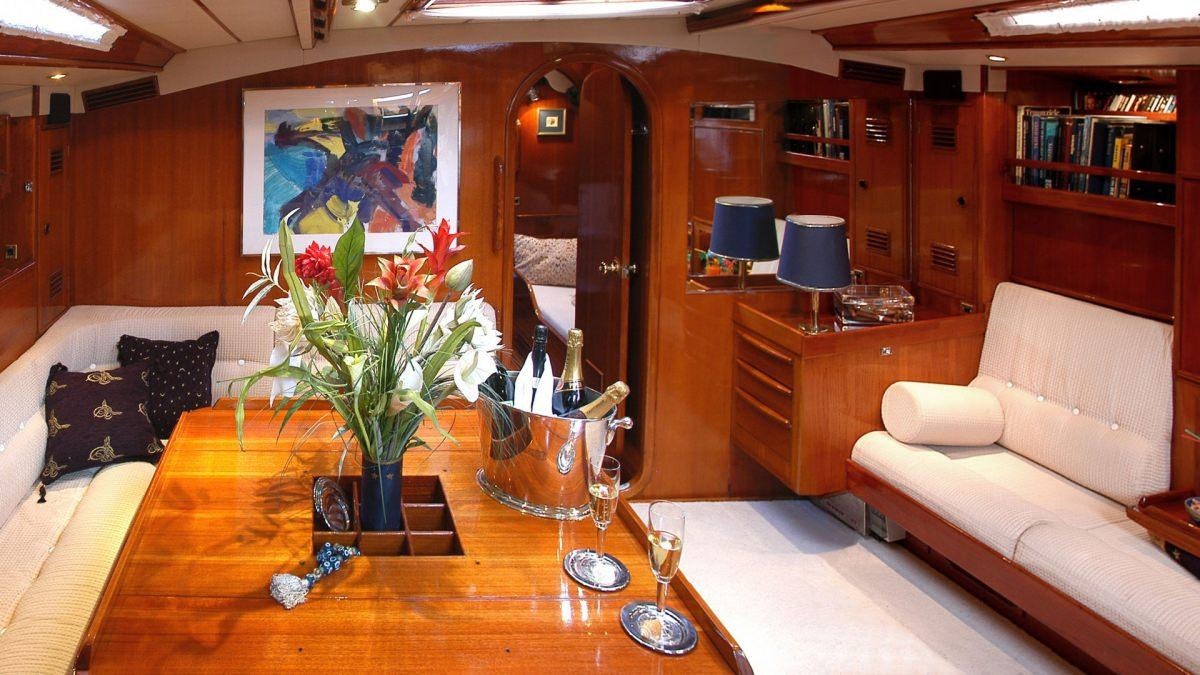 a living room with a table and couches aboard SHAITAN (65' SWAN) Yacht for Charter