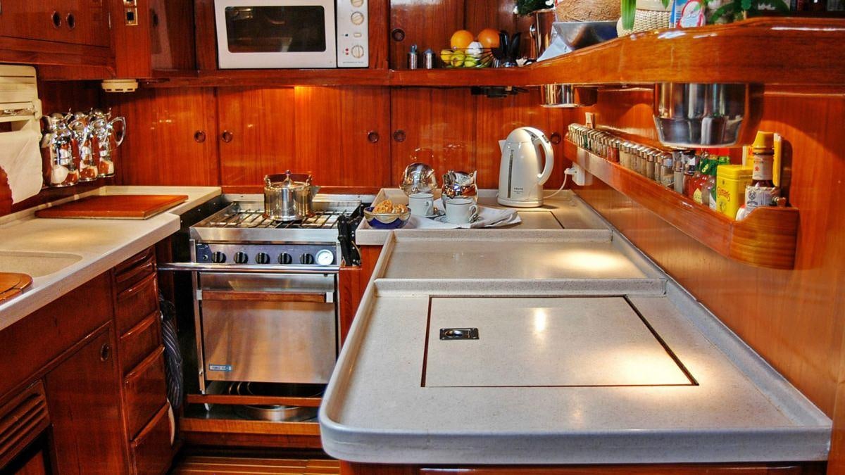 a kitchen with a stove and a microwave aboard SHAITAN (65' SWAN) Yacht for Charter