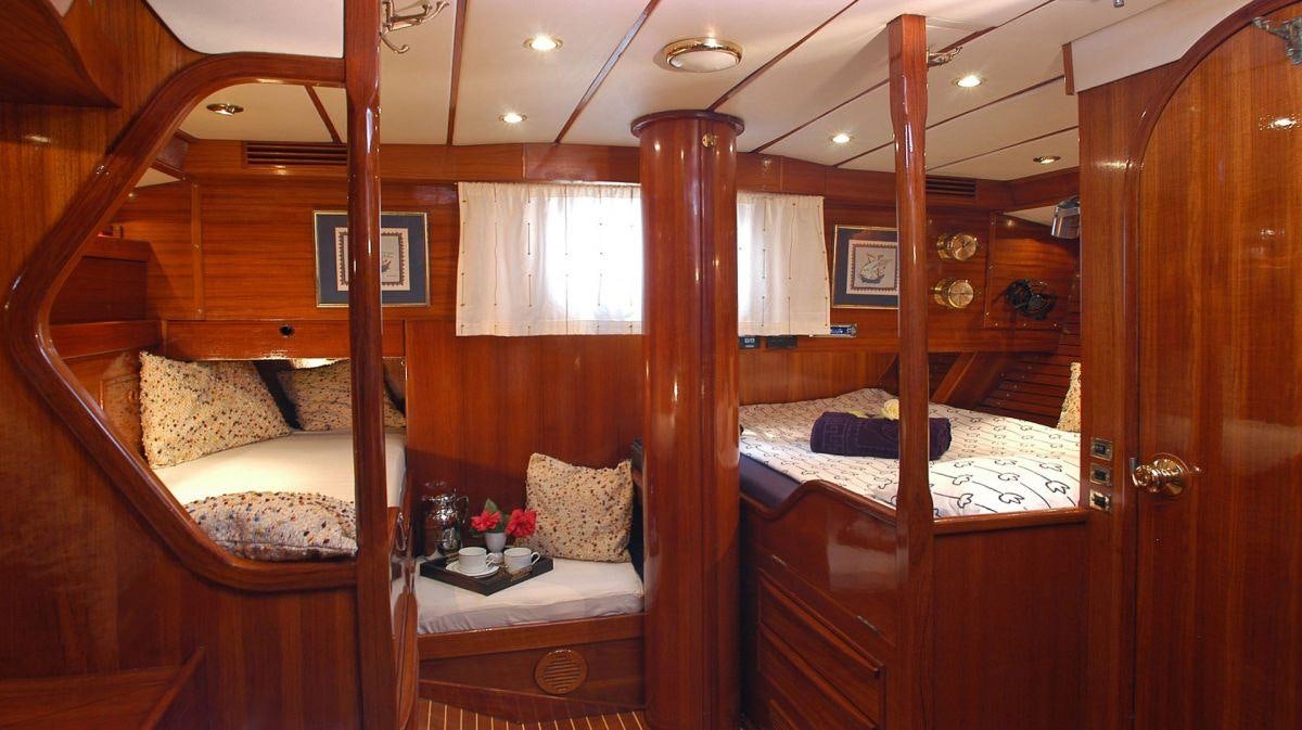 a room with a bed and a wood door aboard SHAITAN (65' SWAN) Yacht for Charter