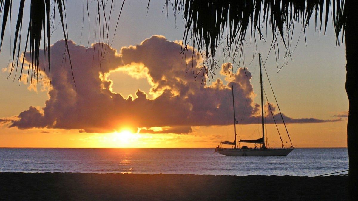 a sunset over a beach with boats aboard SHAITAN (65' SWAN) Yacht for Charter