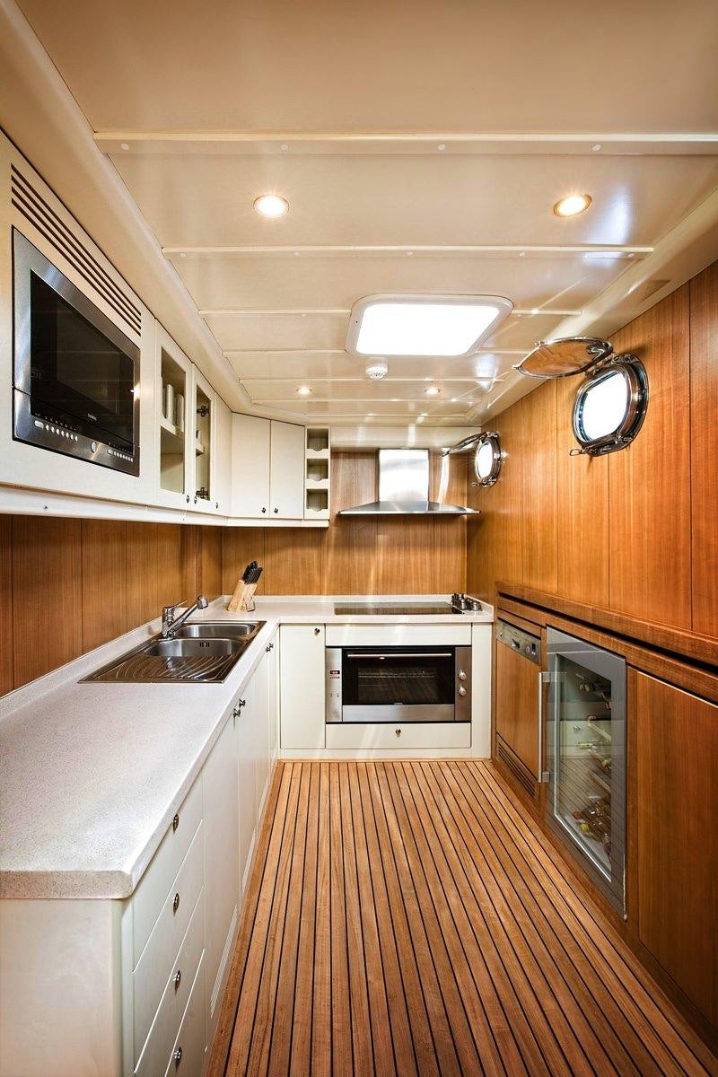 a kitchen with wooden cabinets aboard MISS B Yacht for Charter
