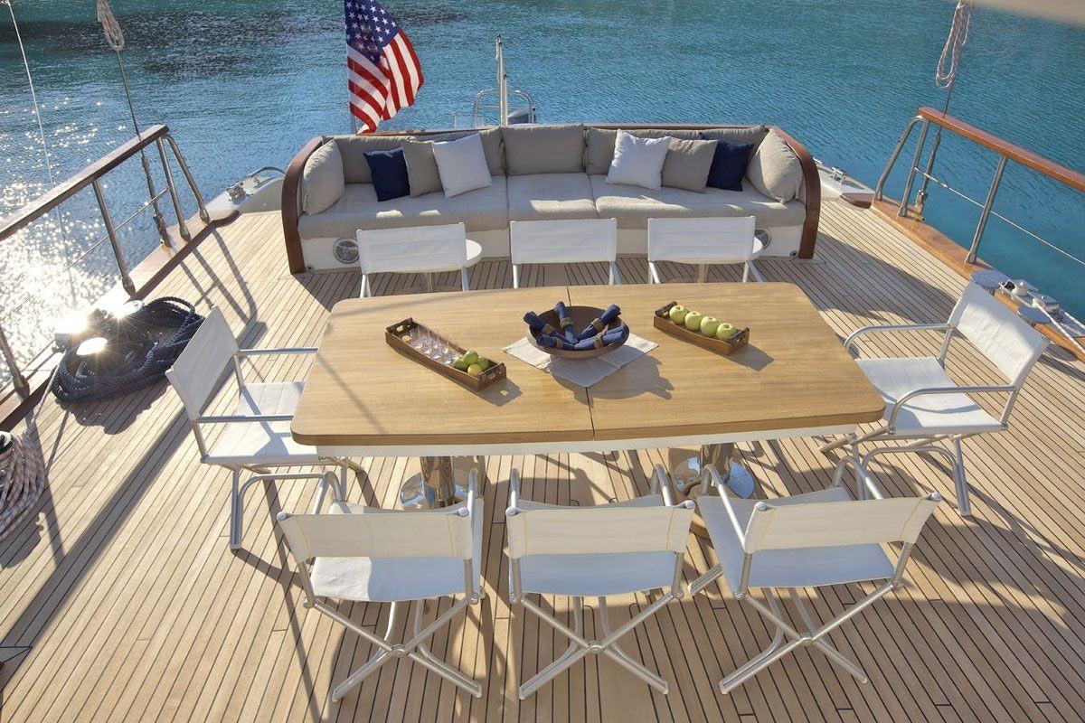 a deck with a boat and chairs on it aboard MISS B Yacht for Charter
