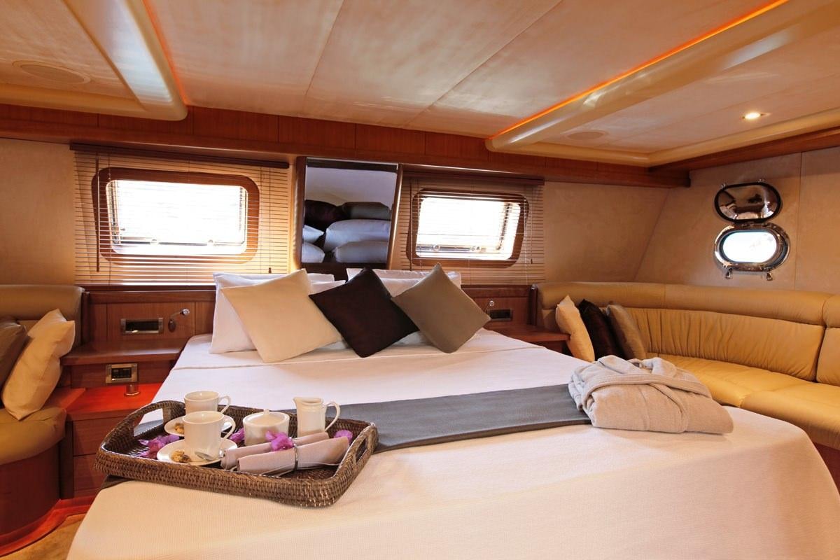 a bedroom with a bed and a window aboard MISS B Yacht for Charter