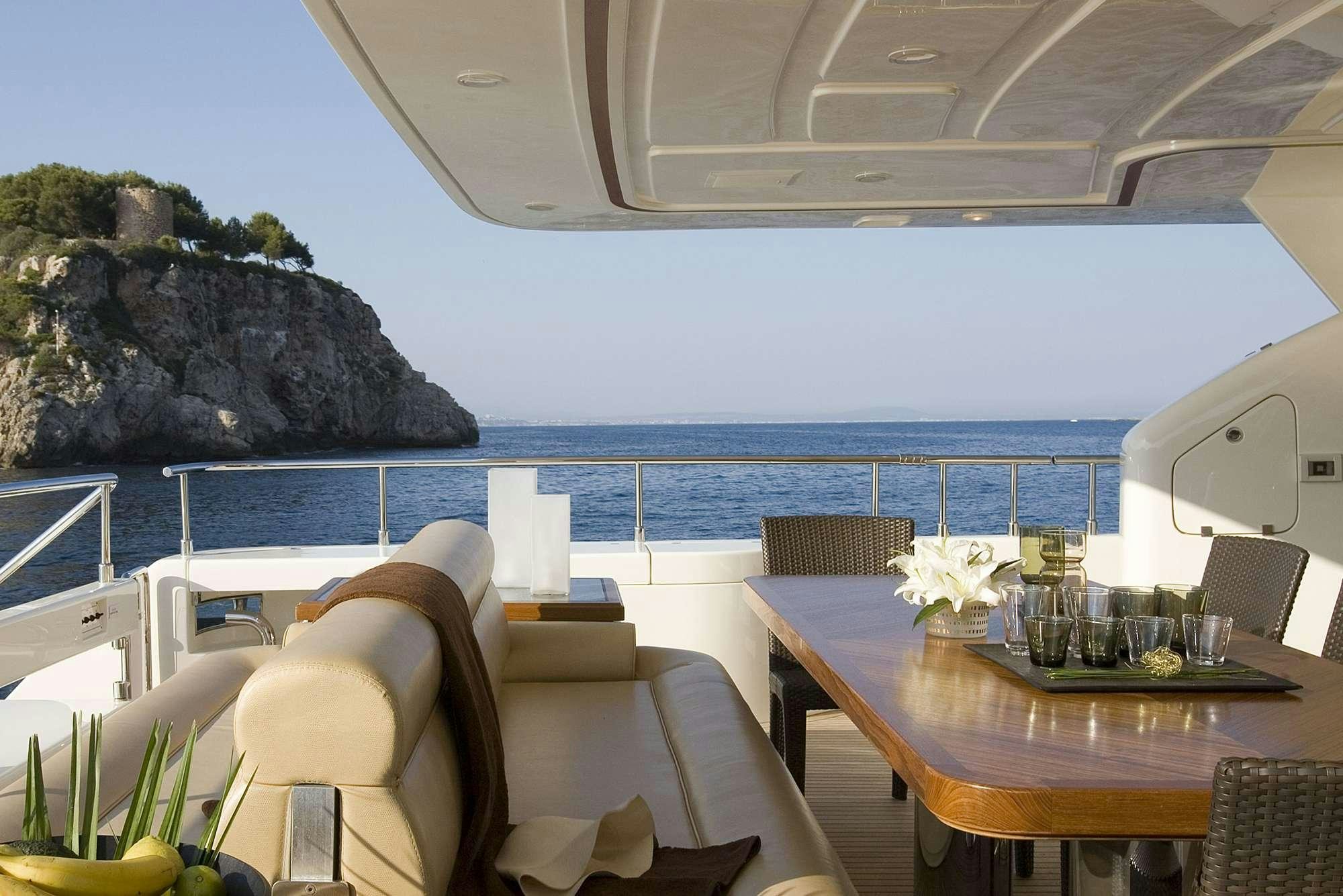 a table and chairs on a balcony aboard PAREAKKI Yacht for Charter