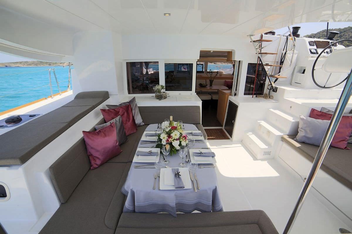 a living room with a large white table and a large window aboard DANIELA II Yacht for Charter