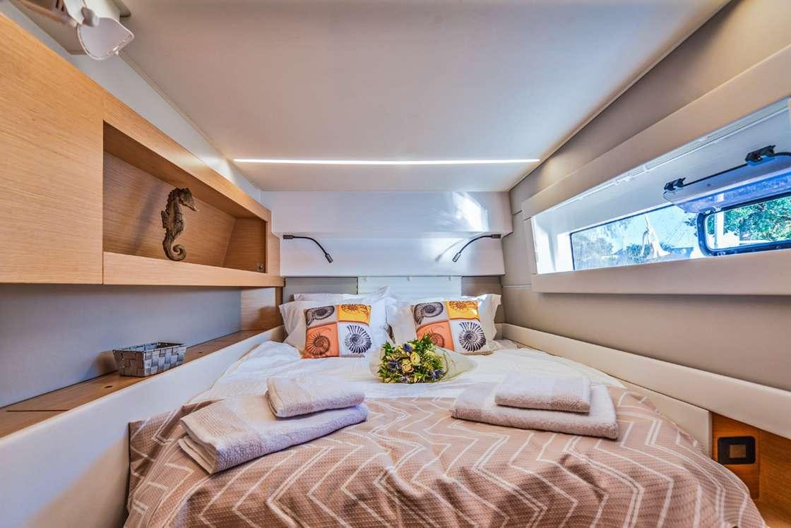 a bedroom with a bed and a window aboard ODYSSEY Yacht for Charter