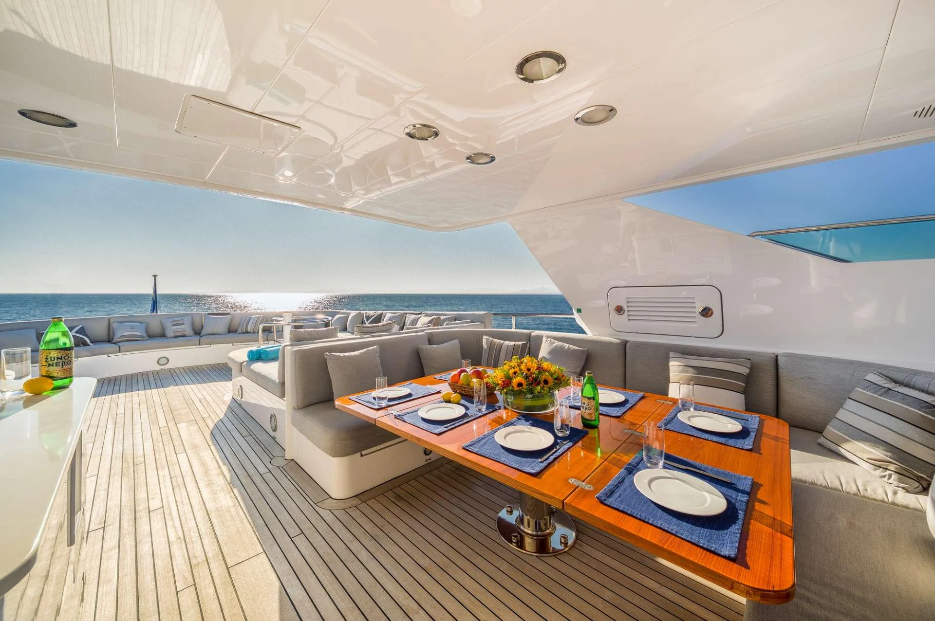 a room with a couch and a table with food on it aboard MILOS AT SEA Yacht for Charter
