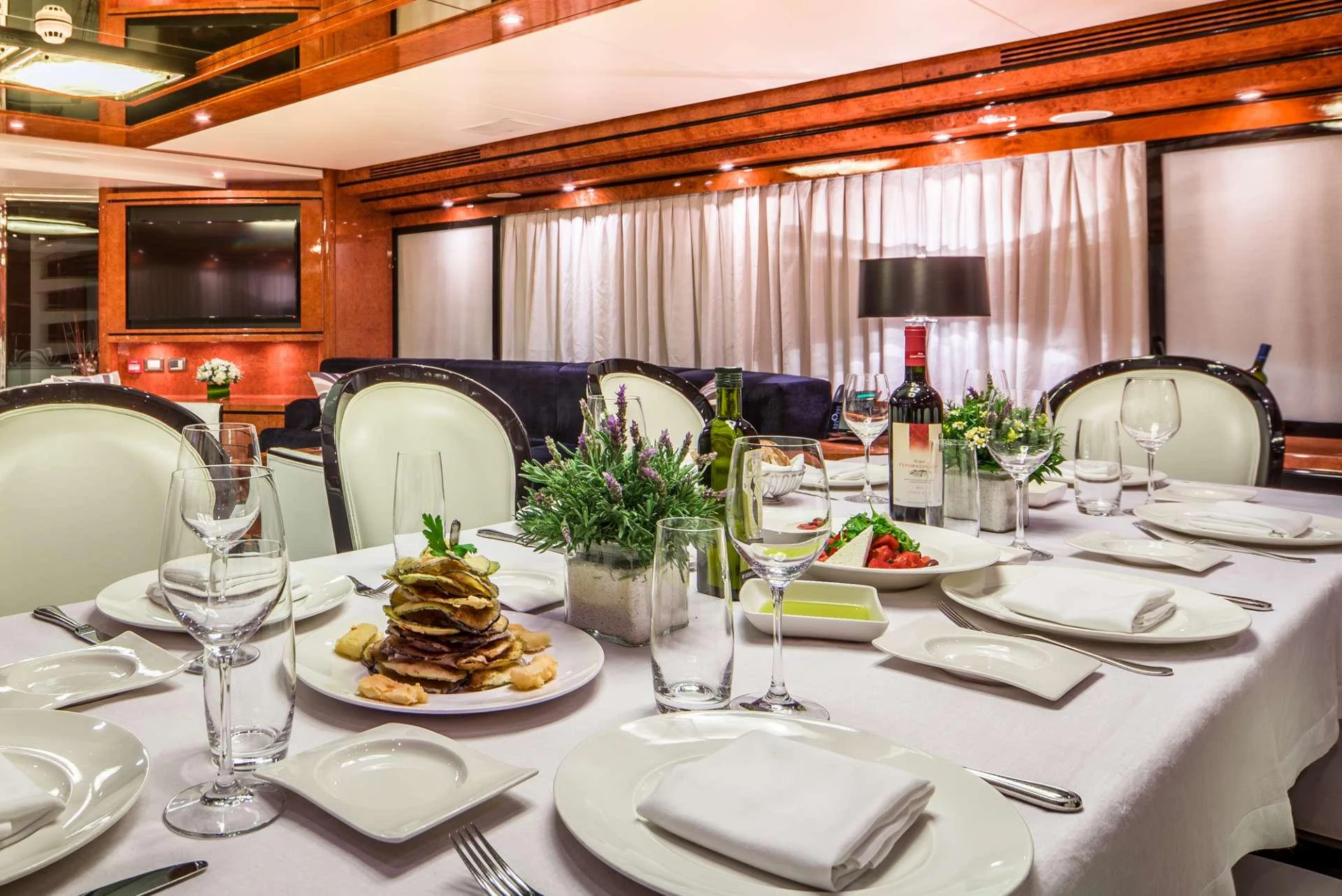 a table set with food and wine aboard MILOS AT SEA Yacht for Charter