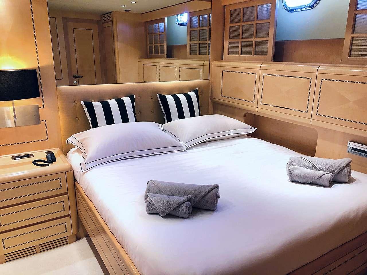 a bed with white sheets aboard MAMBA Yacht for Charter