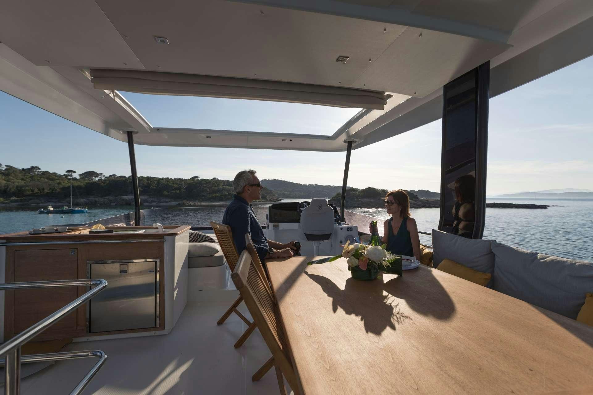 a man and woman sitting at a table on a boat aboard ENDLESS BEAUTY Yacht for Charter