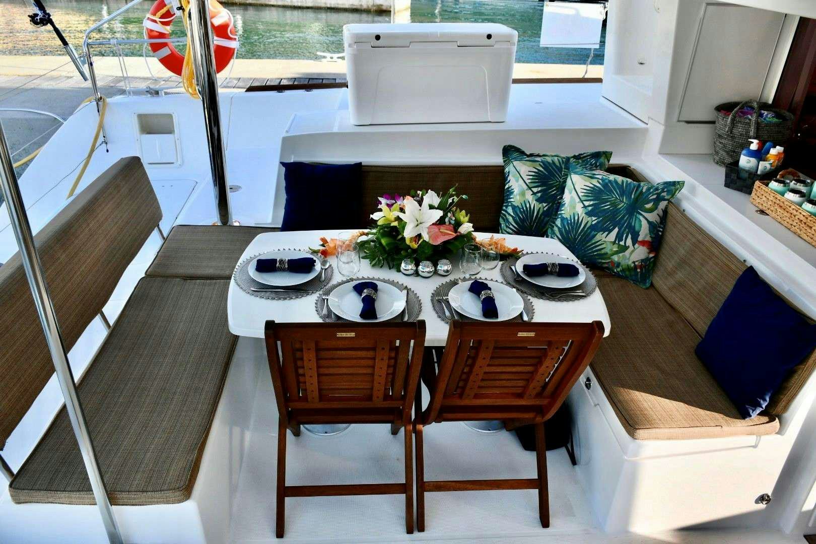 a table with chairs and a couch aboard CHAOS INTERRUPTED Yacht for Charter