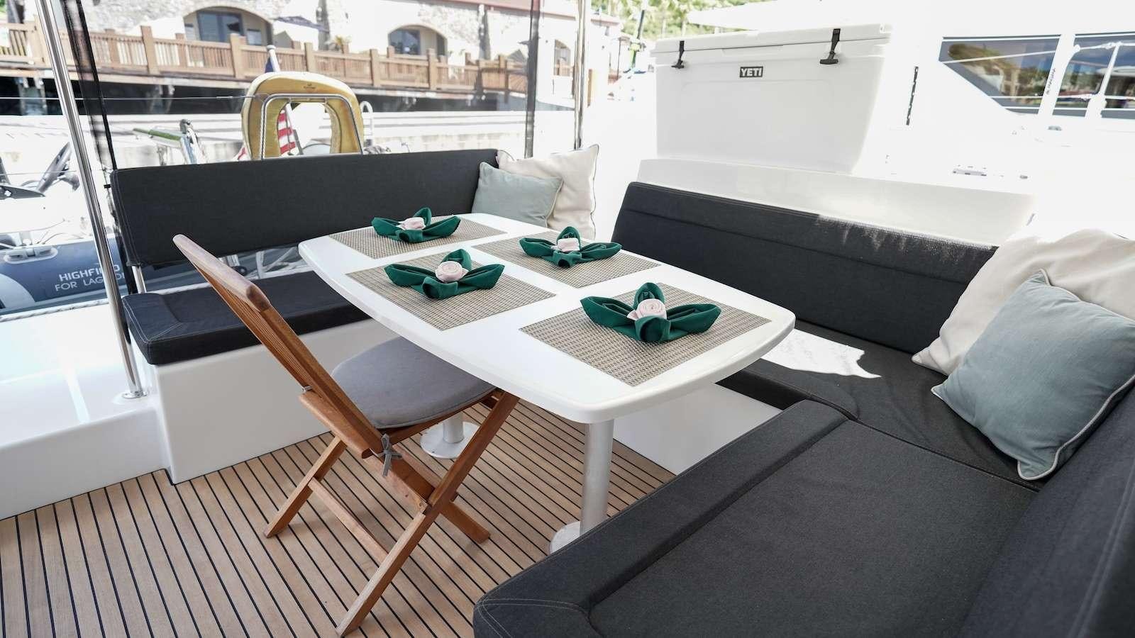 a table with a couch and a chair in a room with a window aboard FLOATATION THERAPY Yacht for Charter