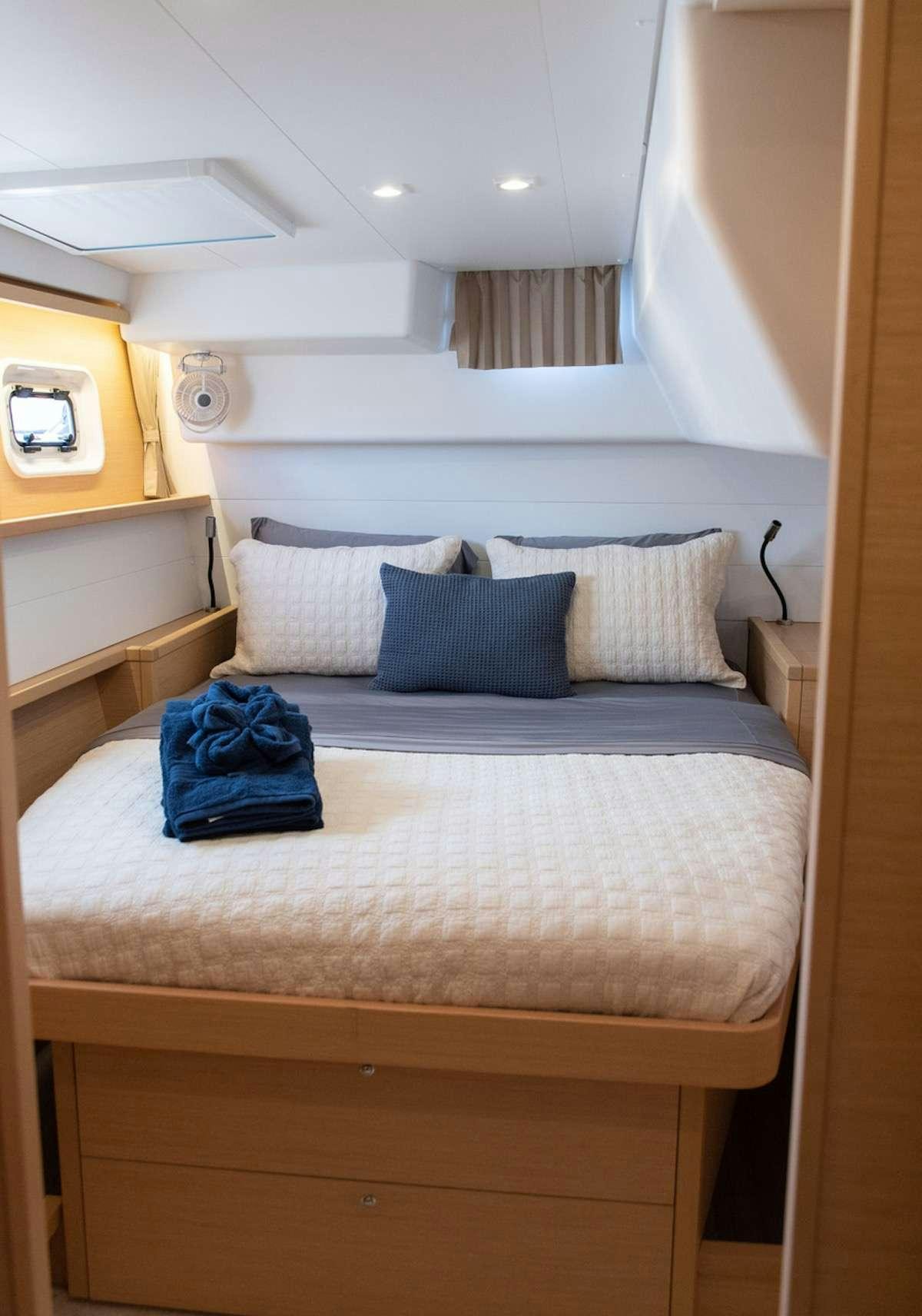 a bed with blue sheets aboard FLOATATION THERAPY Yacht for Charter