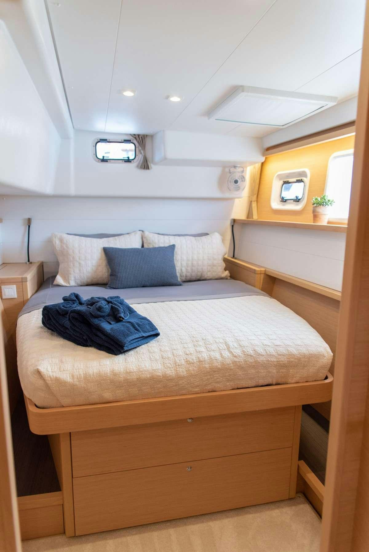 a bed with a blue blanket on it aboard FLOATATION THERAPY Yacht for Charter