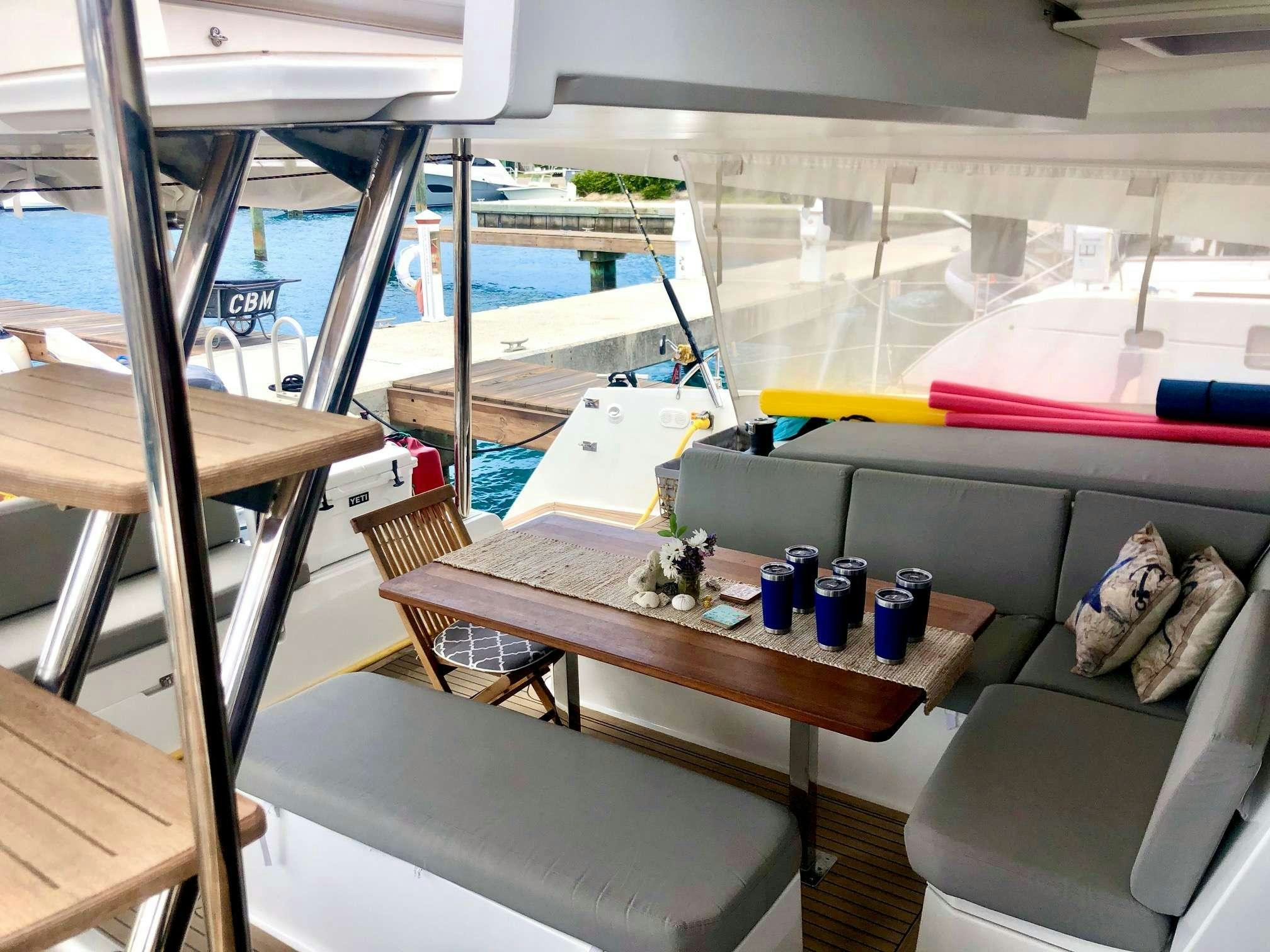 a room with a couch and a table with objects on it aboard Ruckus Yacht for Charter