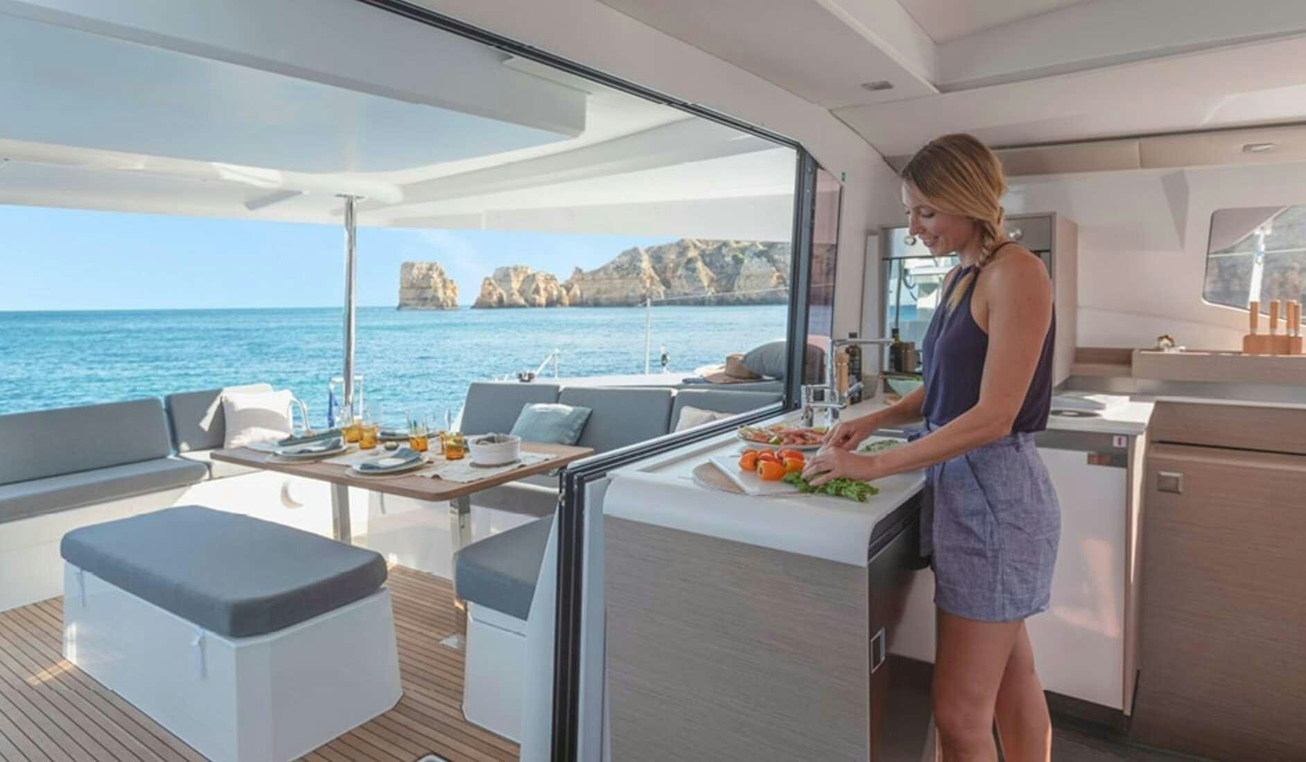 a woman standing in a kitchen aboard Ruckus Yacht for Charter