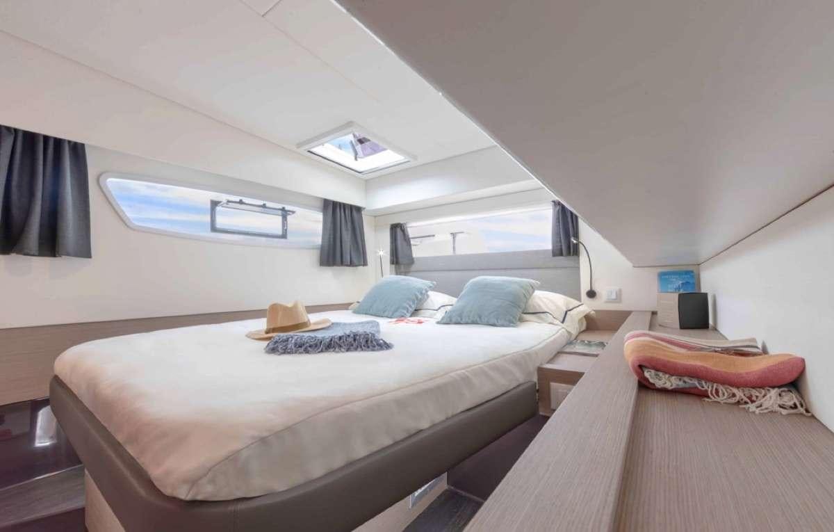 a room with a bed and a desk aboard Ruckus Yacht for Charter