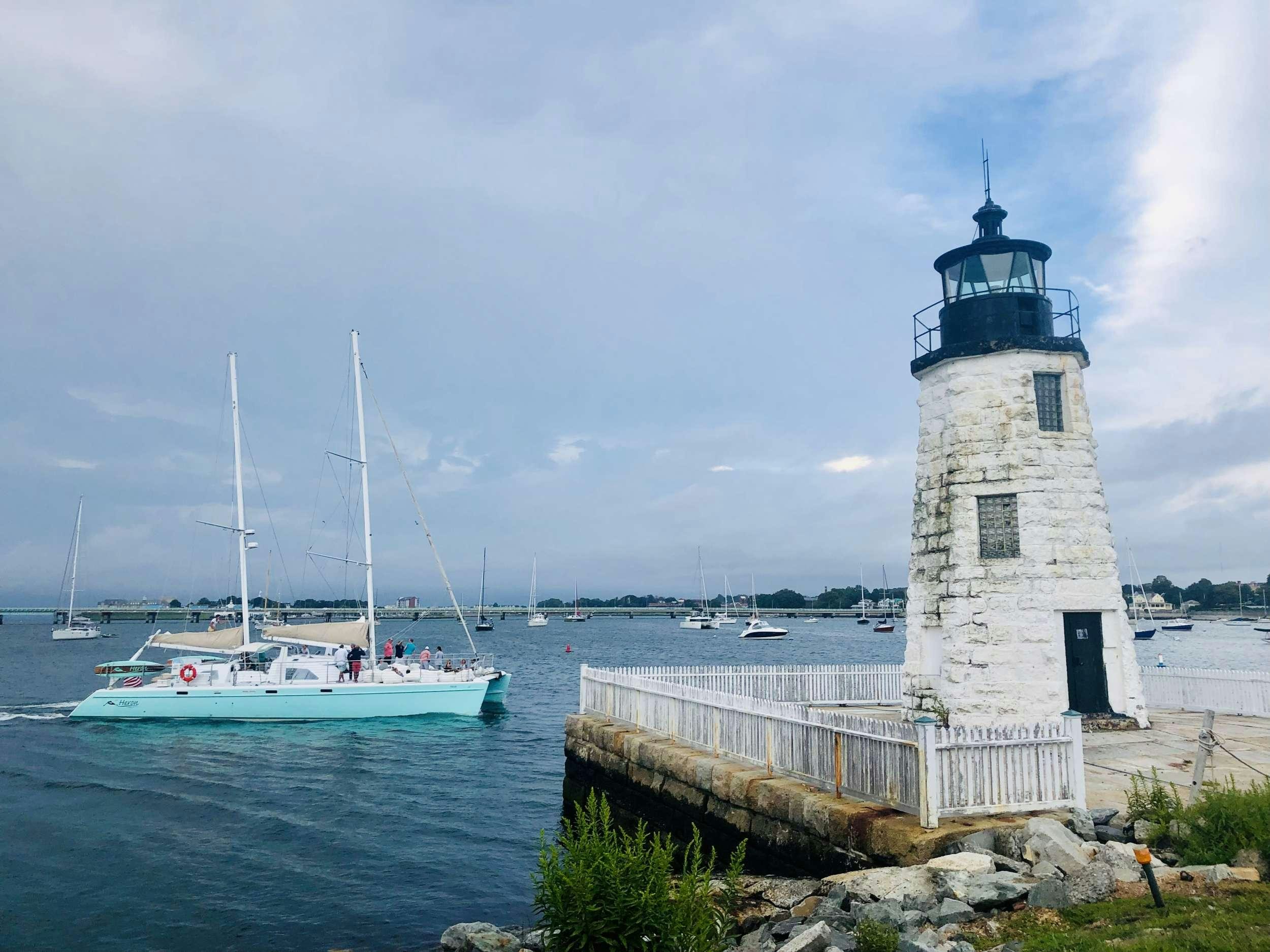 a lighthouse next to a body of water aboard HERON Yacht for Charter
