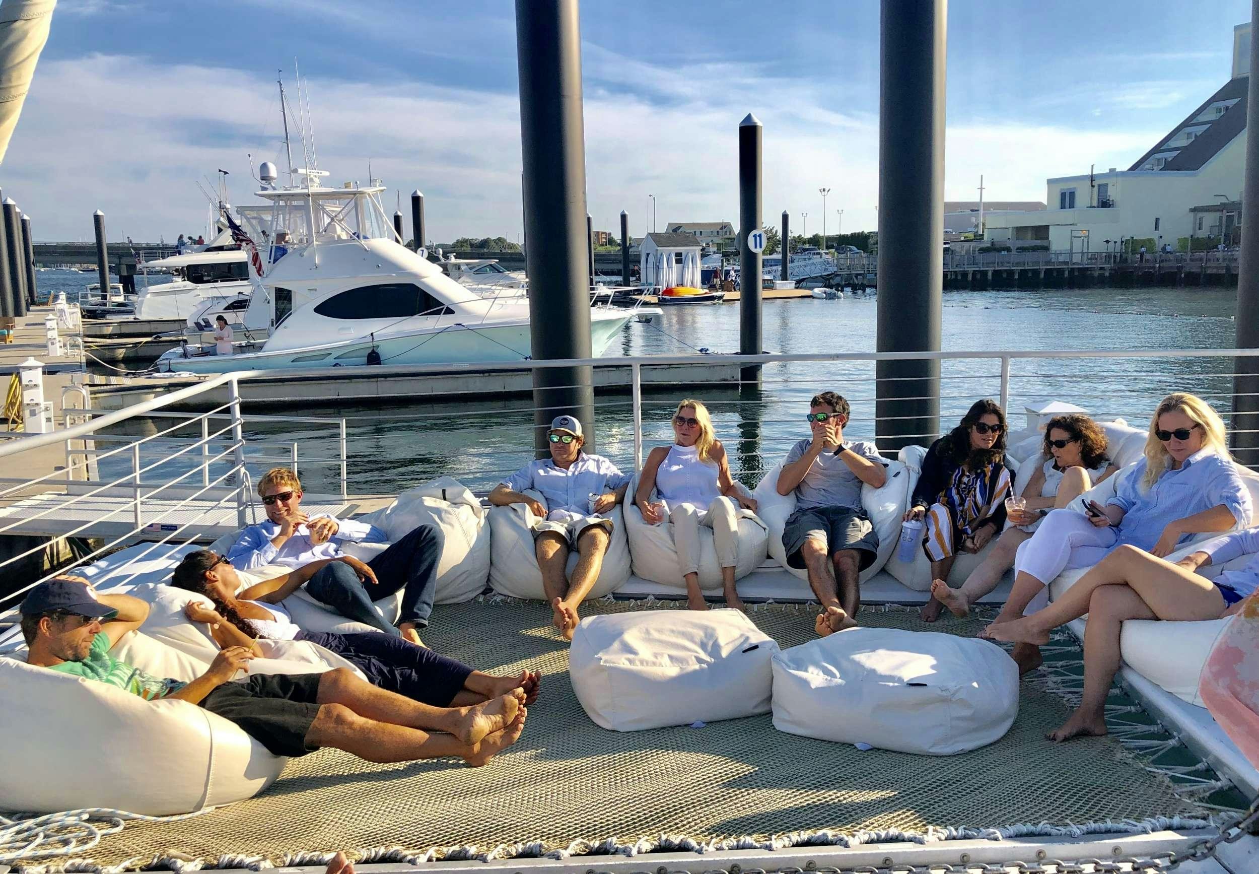 a group of people sitting on a dock aboard HERON Yacht for Charter