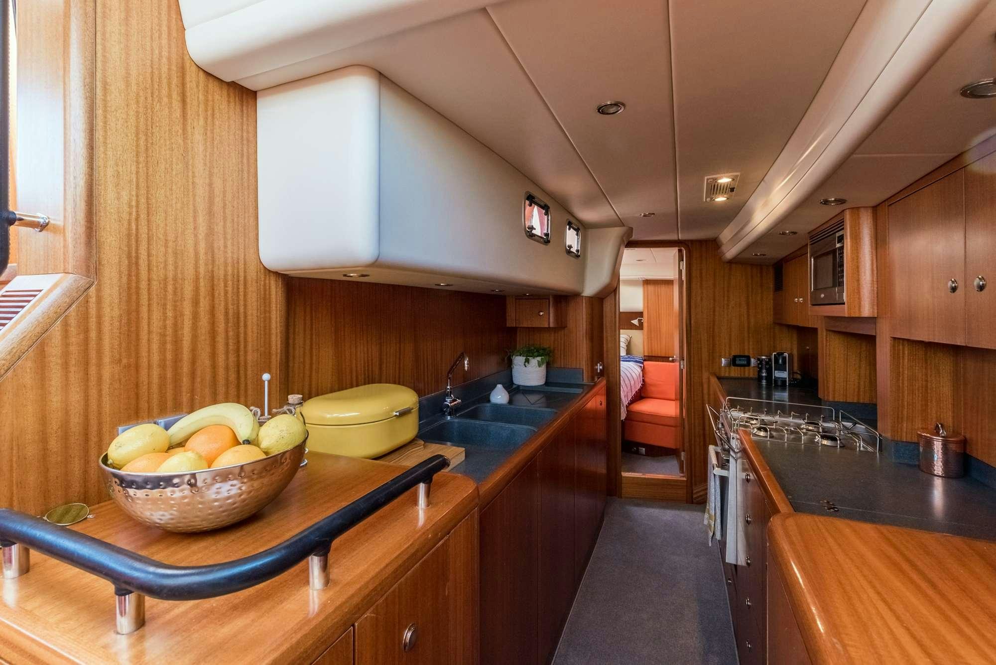 a kitchen with a bowl of fruit aboard LUNULATA  Yacht for Charter