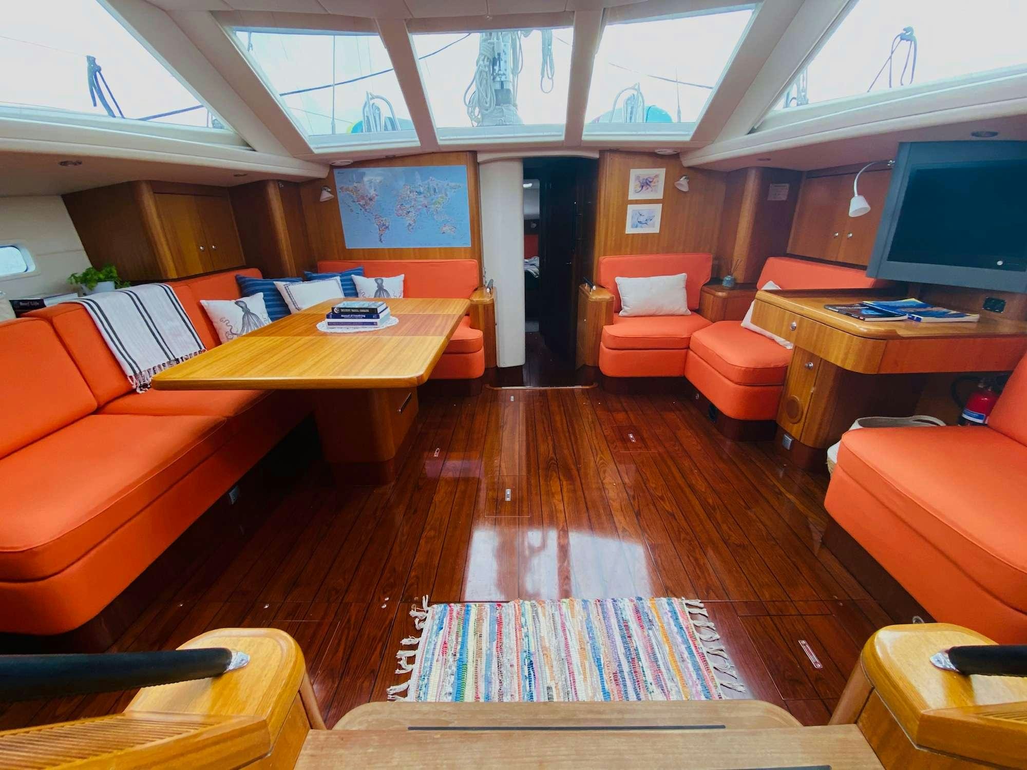 an empty classroom with orange couches aboard LUNULATA  Yacht for Charter