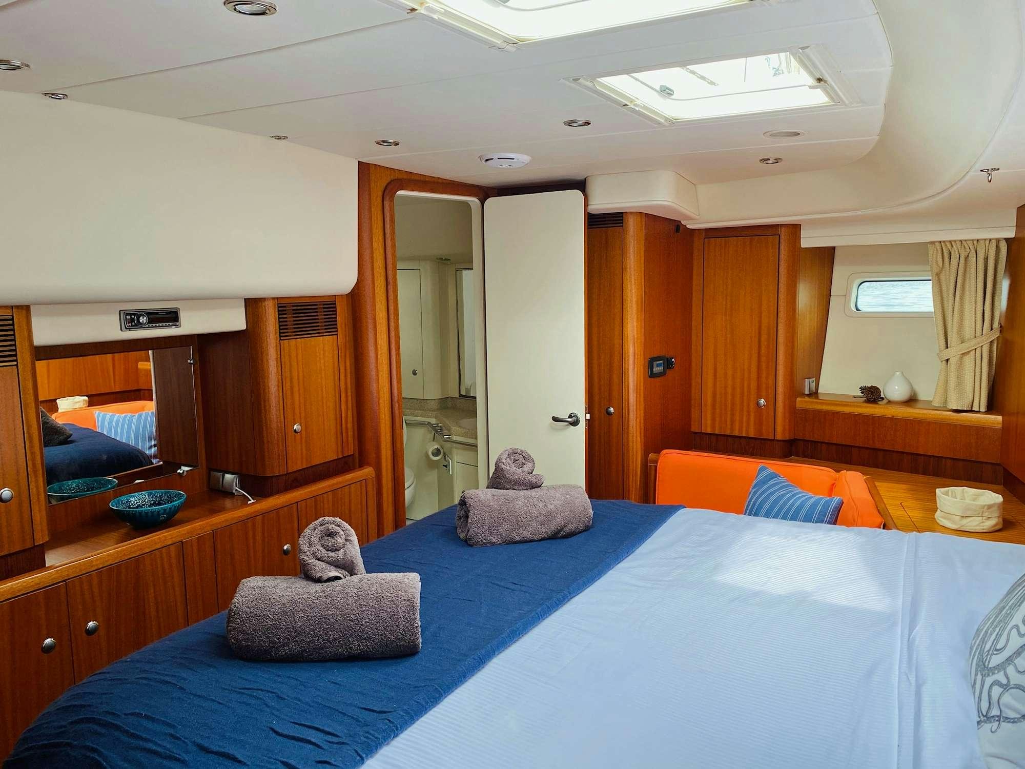 a bedroom with a bed and a desk aboard LUNULATA  Yacht for Charter