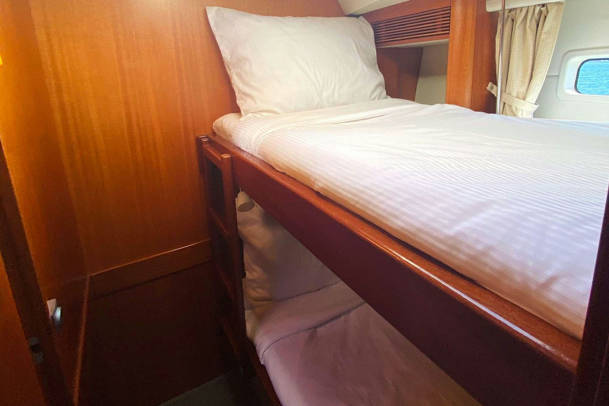 a bed with white sheets aboard LUNULATA  Yacht for Charter