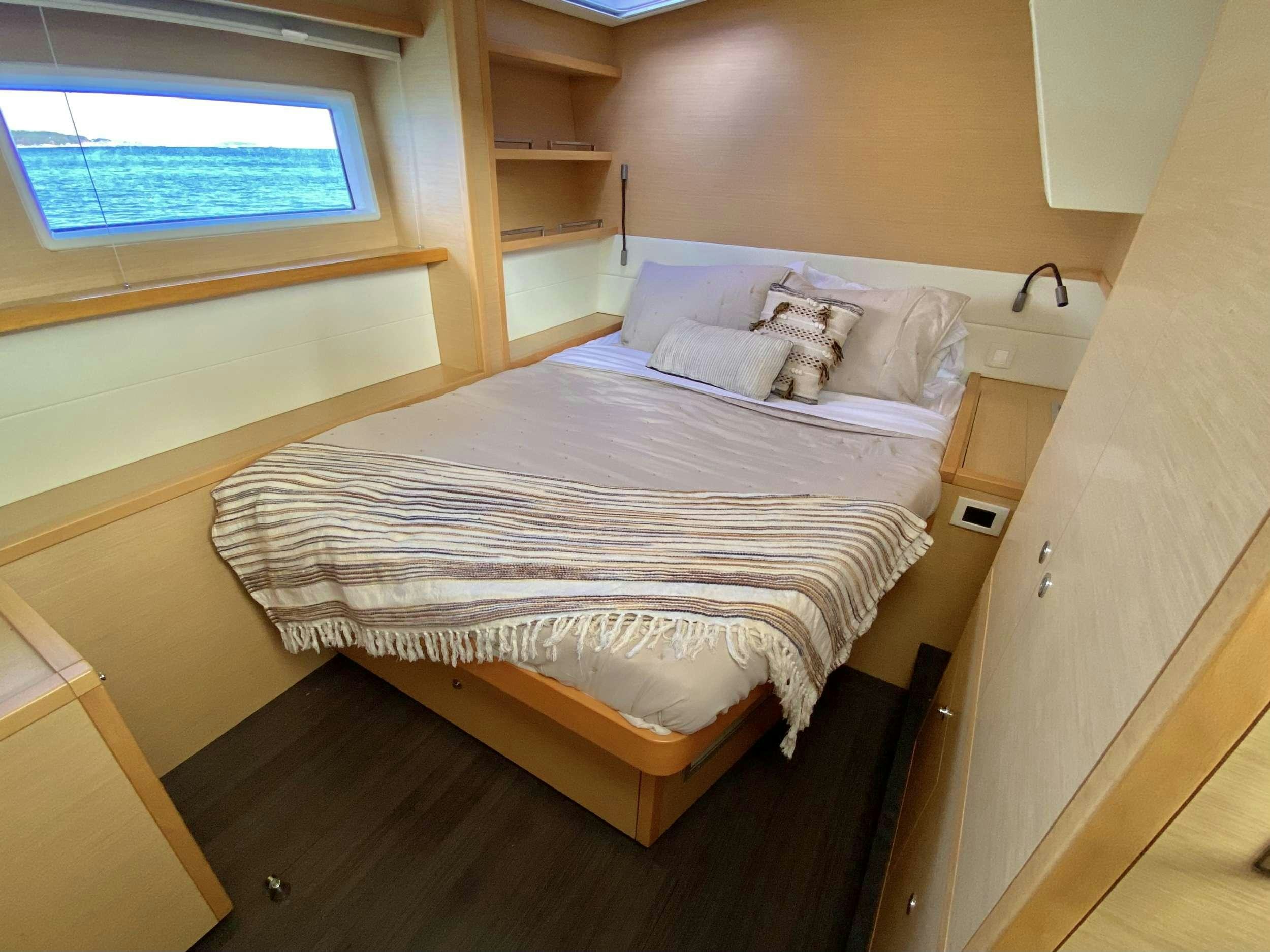 a bed with a white sheet aboard CHAMPAGNE L52 Yacht for Charter