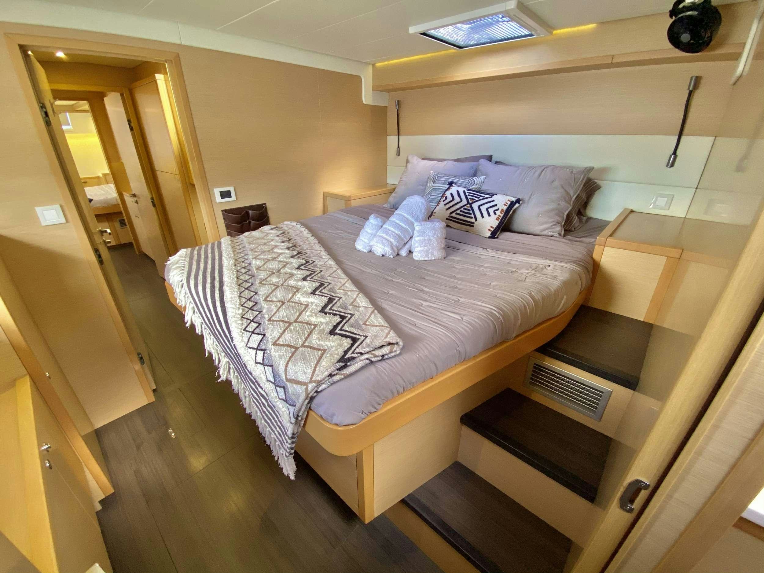 a bed with white sheets aboard CHAMPAGNE L52 Yacht for Charter