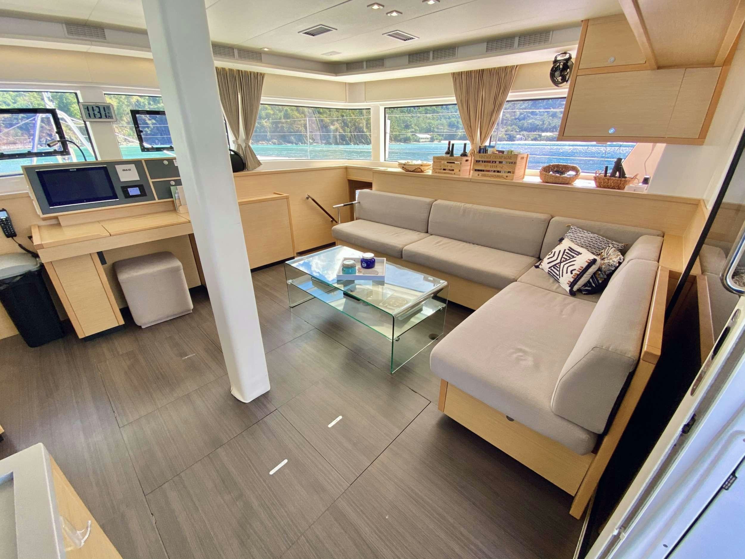 a living room with a couch and a table aboard CHAMPAGNE L52 Yacht for Charter