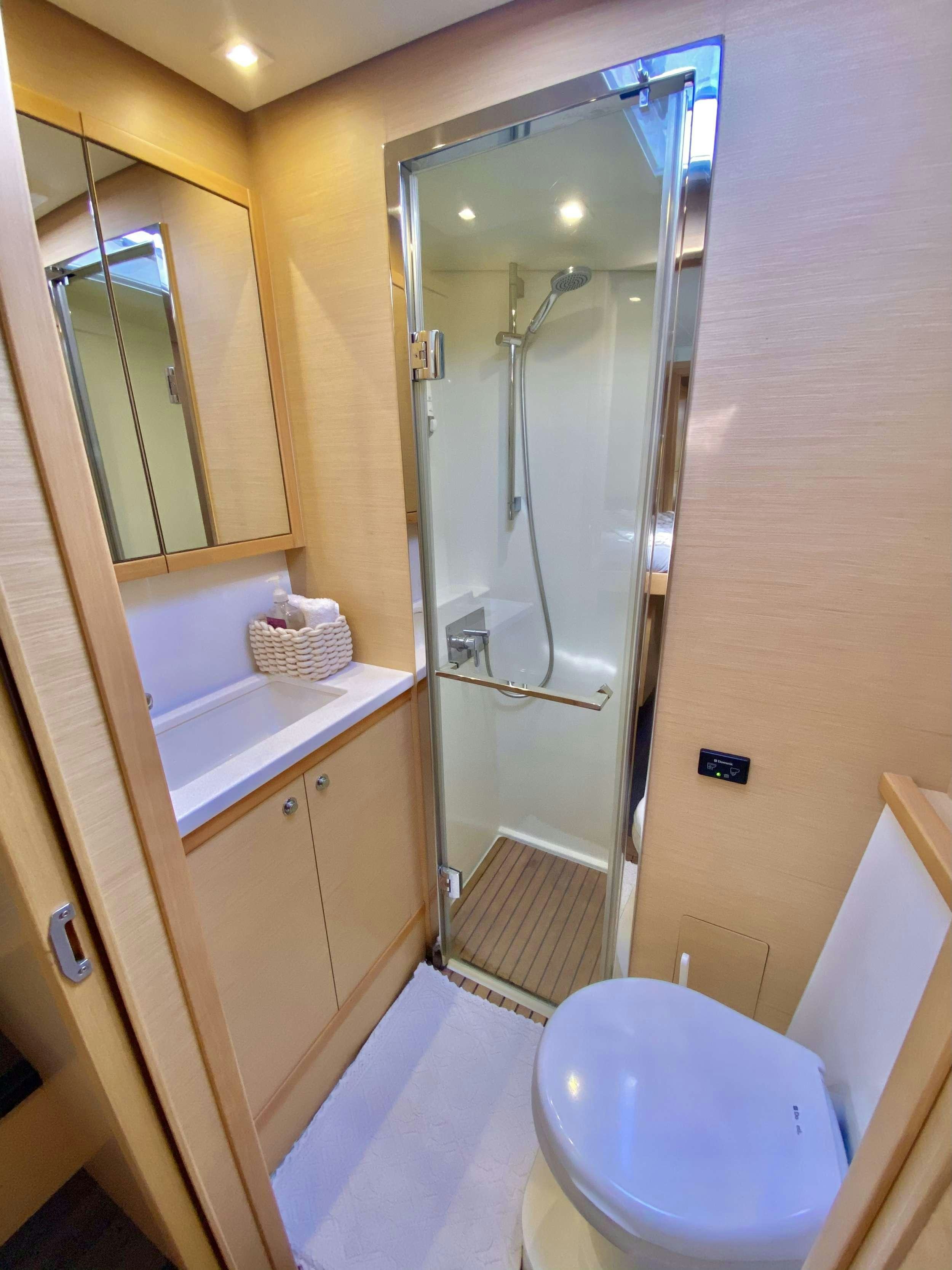 a bathroom with a glass shower door aboard CHAMPAGNE L52 Yacht for Charter