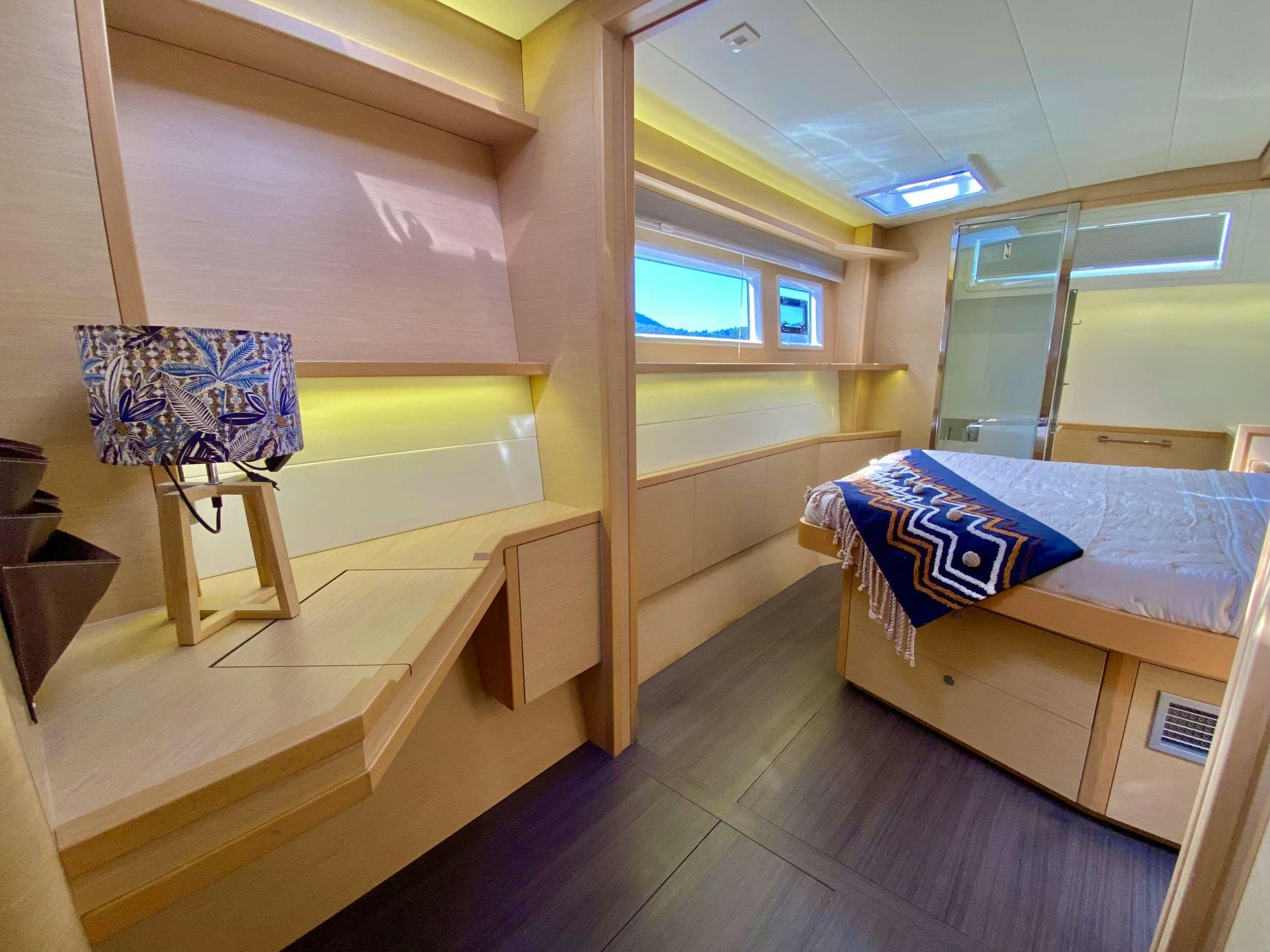 a room with a bed and a desk aboard CHAMPAGNE L52 Yacht for Charter